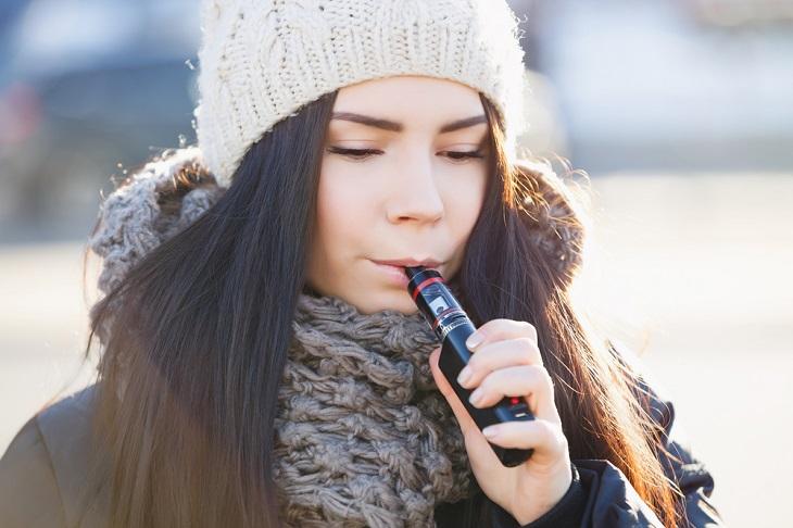 A person wearing a hat talking on a cell phone Description automatically generated