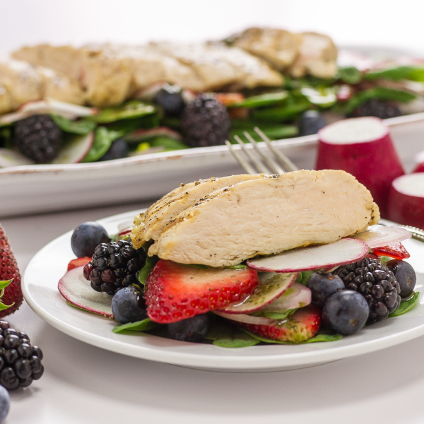 grilled chicken on top of spinach and berries