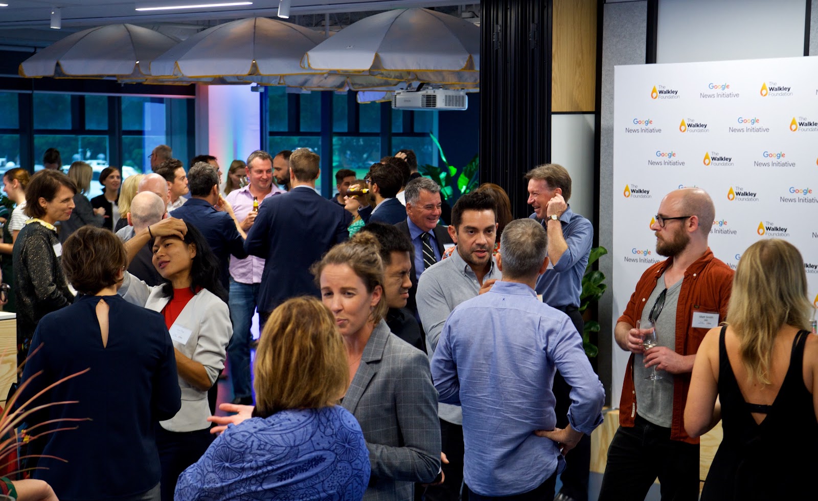 A photo showing attendees mingling at the Google News Initiative event