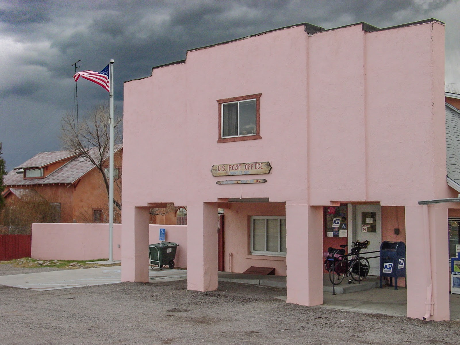 A pink two-story building with American flag against a dark sky.