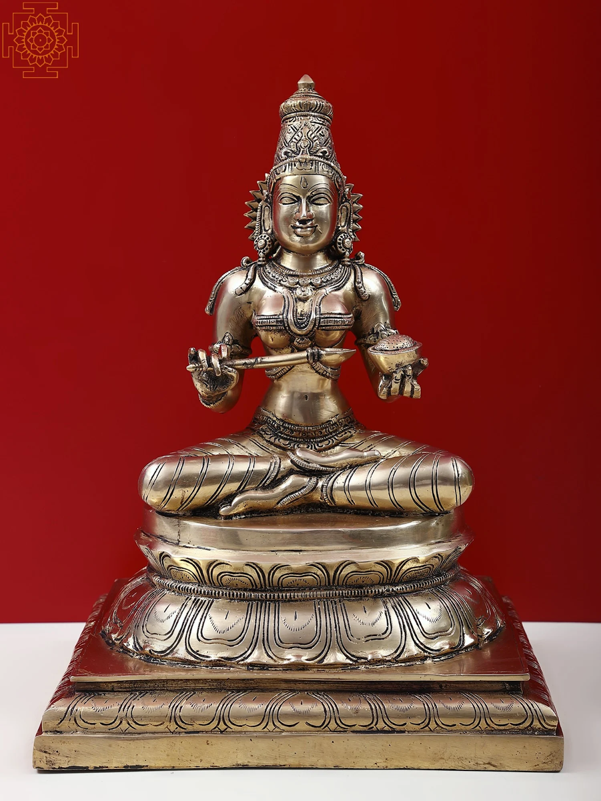 A statue of Annapurna holding a spoon and bowl while sitting cross-legged. 