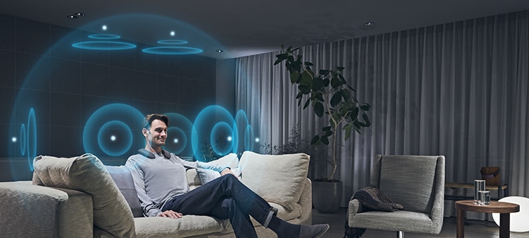 Image of man in living room watching BRAVIA TV with 360 Spatial Sound