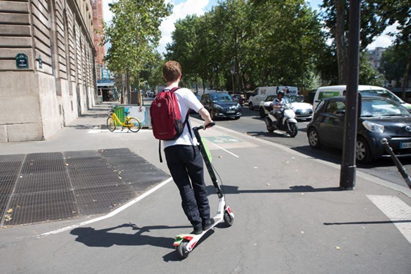 personne sur une trottinette électrique dans une rue de paris 