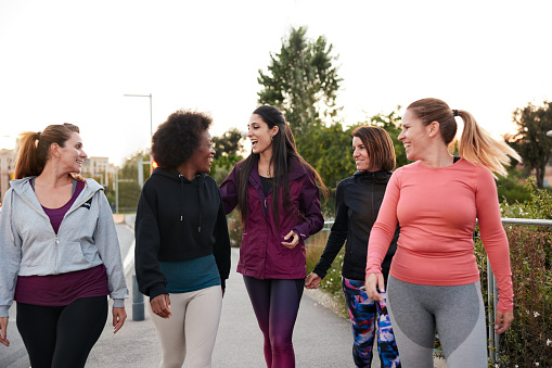 group of women walking down a sidewalk
