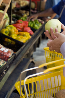 Example image 2: photograph of a hand picking up grocery into a basket in supermarket