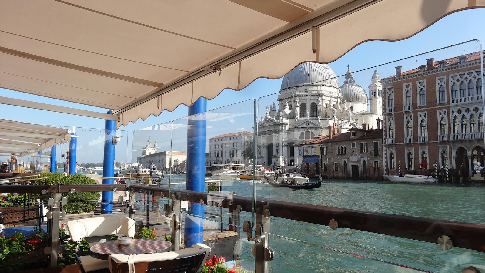 gritti palace terrace restaurant, outdoor dining with a view of canal grande. Sunny day, no tourists and canal full of boats. Be sure to see it on an Italy road trip