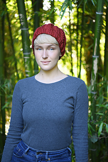 woman wearing red cable knit hat in the woods