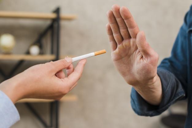 Man refusing cigarettes offered by his female colleague Premium Photo