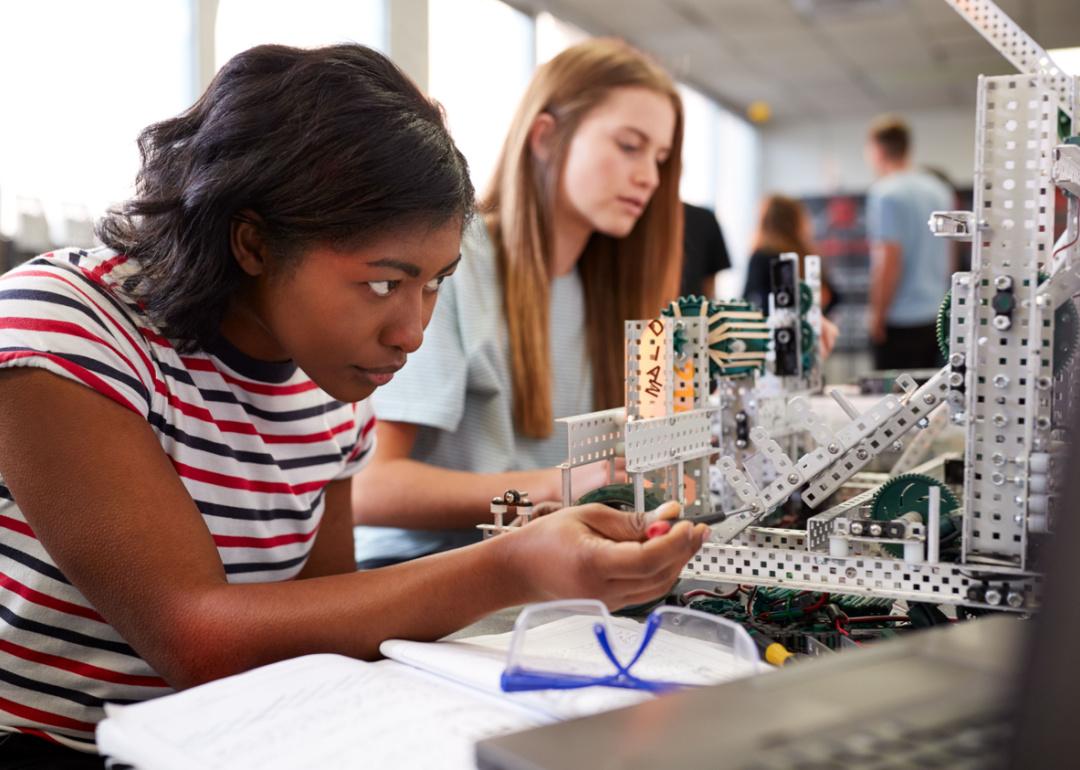 Two female students building machine in science robotics class.