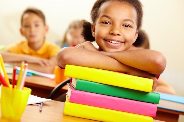 Menina de sorriso com livros prontos Foto gratuita