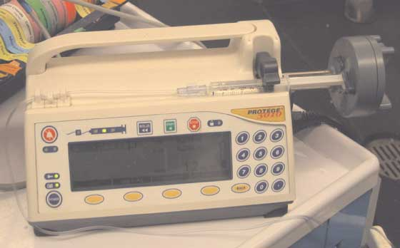 A CRI syringe pump with syringe attached. Desired doses can be pre-programmed into the pump. 