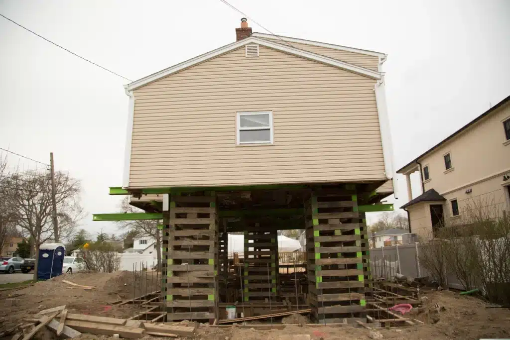 vinyl siding house lifted using jacks