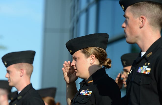 Paige Albertson, from Nantucket, salutes as the flag is raised at Massachusetts Maritime Academy early Tuesday on the next-to-last morning formation of the year. Steve Heaslip/Cape Cod Times