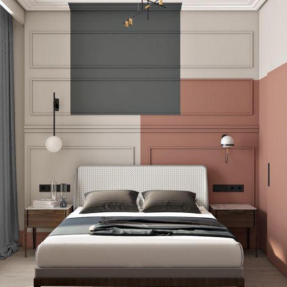 Quarto de casal com parede de fundo da cama com pintura orgânica em tons de rosa e cinza, molduras boiserie na parede, criados mudo amadeirado e piso de madeira