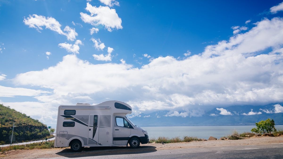 Camper van in front of sea view and blue skies