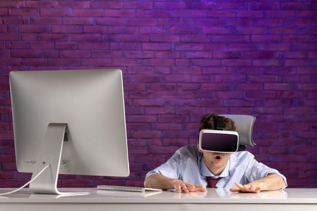 Офисный работник вид спереди за офисным столом, играя в виртуальную реальность Бесплатные Фотографии