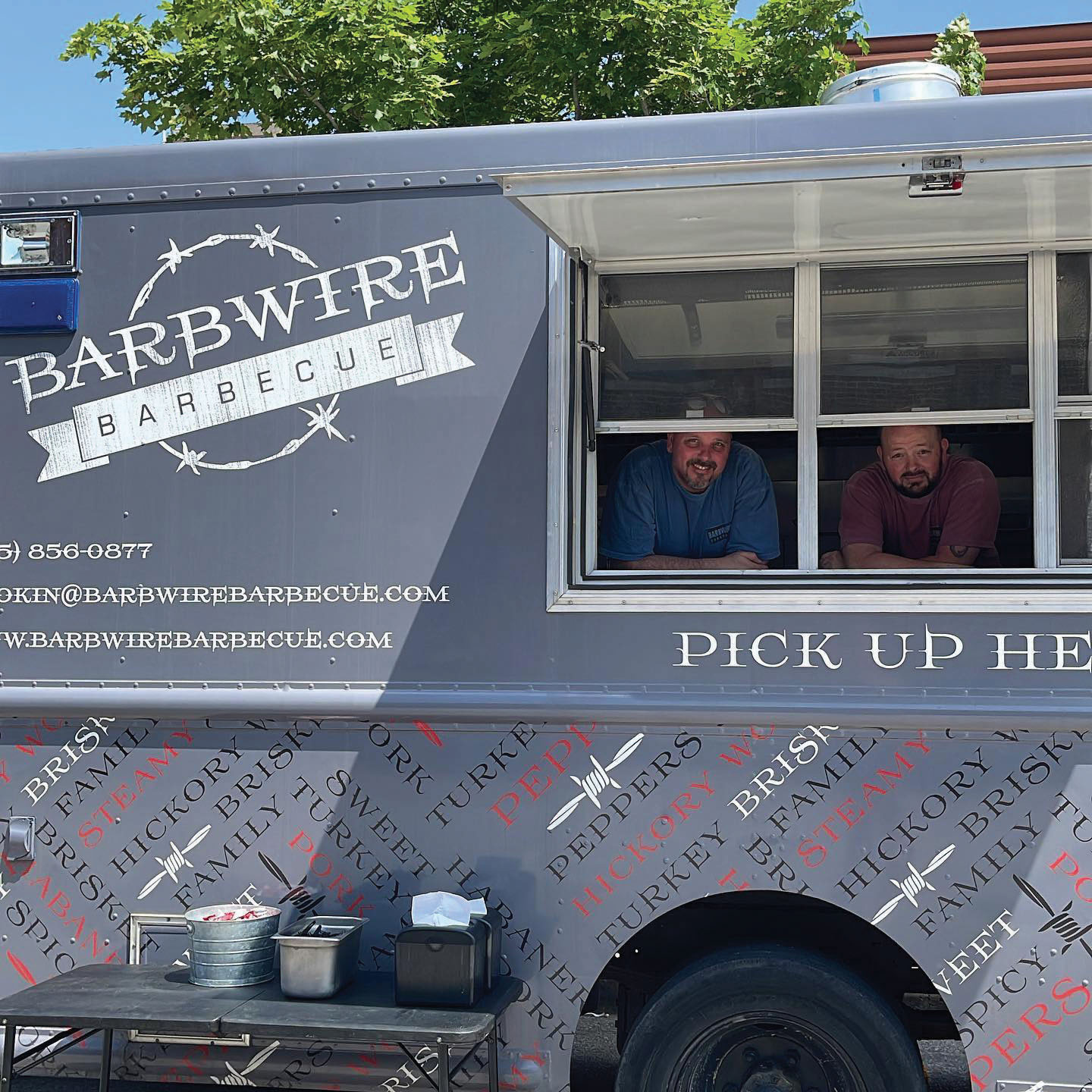 The owners of Barbwire Barbecue look out of the window from their food truck