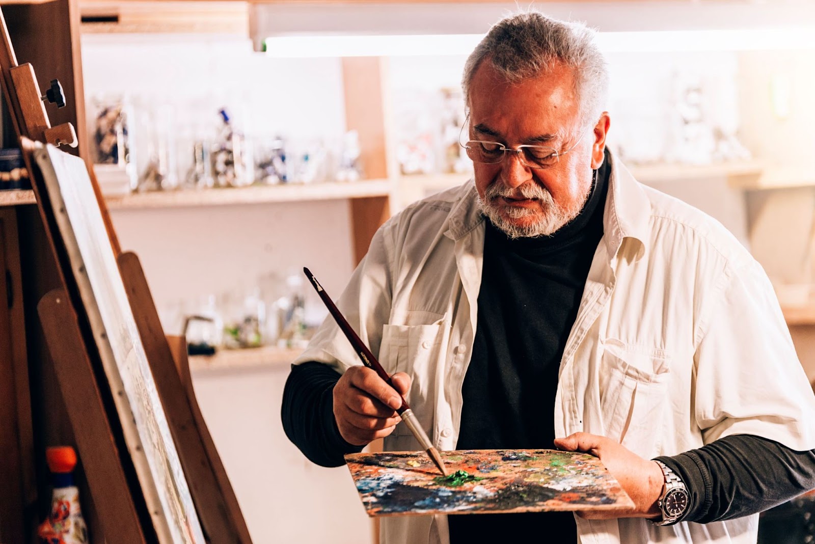 older-male-artist-painting-in-his-studio