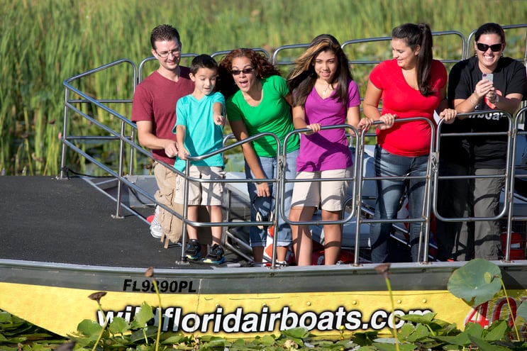 A family enjoys a sunny day on the everglades in a Wild Florida airboat tour