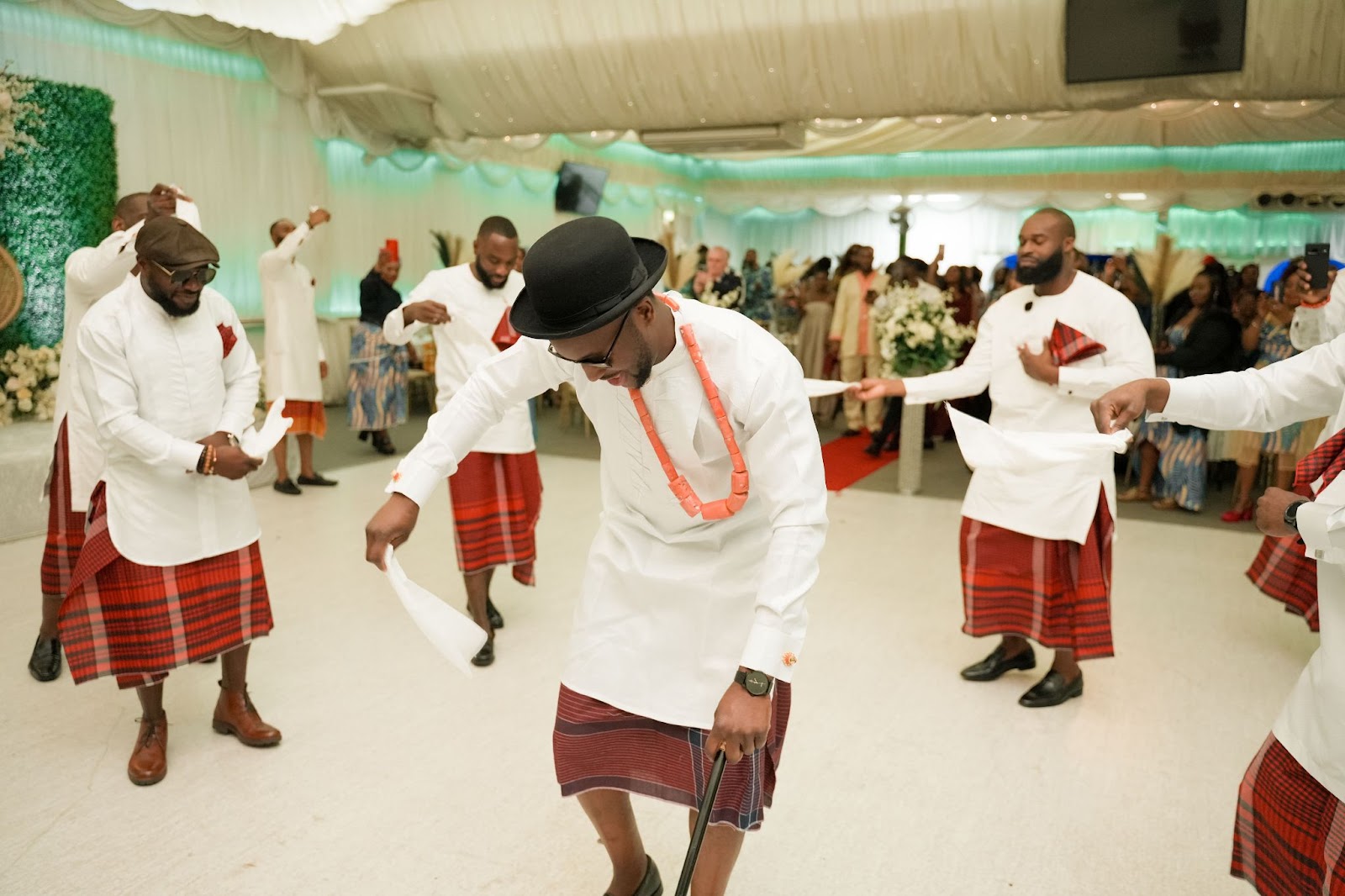 Groom dancing with his groomsmen holding a white napkin