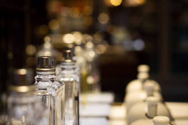 perfume bottles in store display shelf perspective view of white ceramic fragrance bells and perfume bottles in store shelf display with selective focus perfume bottle stock pictures, royalty-free photos & images