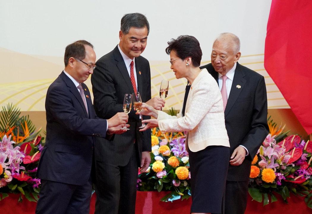在周一上午的庆祝仪式上,香港行政长官林郑月娥与其他官员碰杯,包括香港中联办主任王志民(左)。