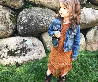 little girl wearing a fringed crochet toddler dress with jean jacket