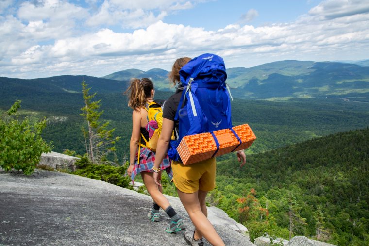 Hikers carrying the NEMO Switchback Sleeping Pad on a backpack.
