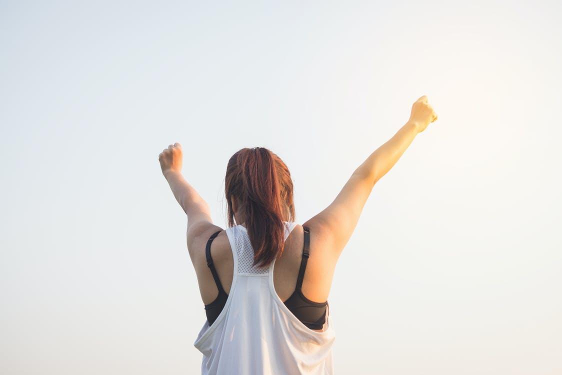 Free Woman Wearing Black Bra and White Tank Top Raising Both Hands on Top Stock Photo