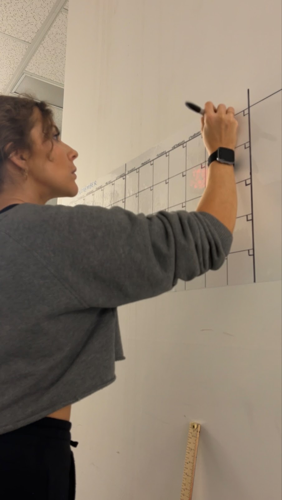 Inspired Idiots Kelsey creating a large wall calendar for the office space