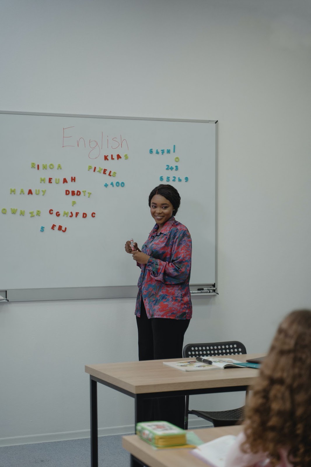 A woman teaching English on a whiteboard