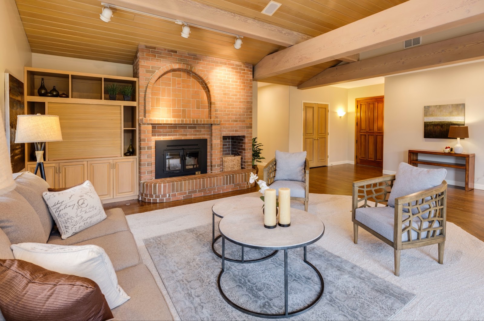 Neutral living room with exposed brick chimney breast and lots of soft furnishings