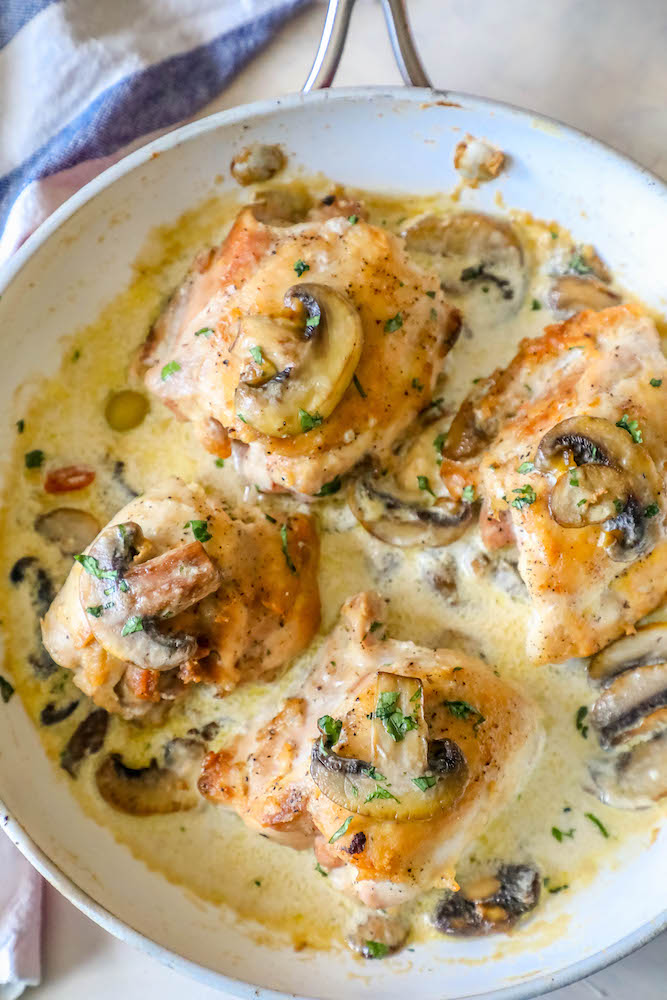 chicken thighs with mushrooms and a creamy garlic sauce in pan picture