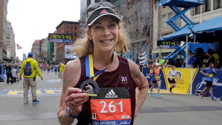 Kathrine Switzer posing with a medal at the Boston Marathon