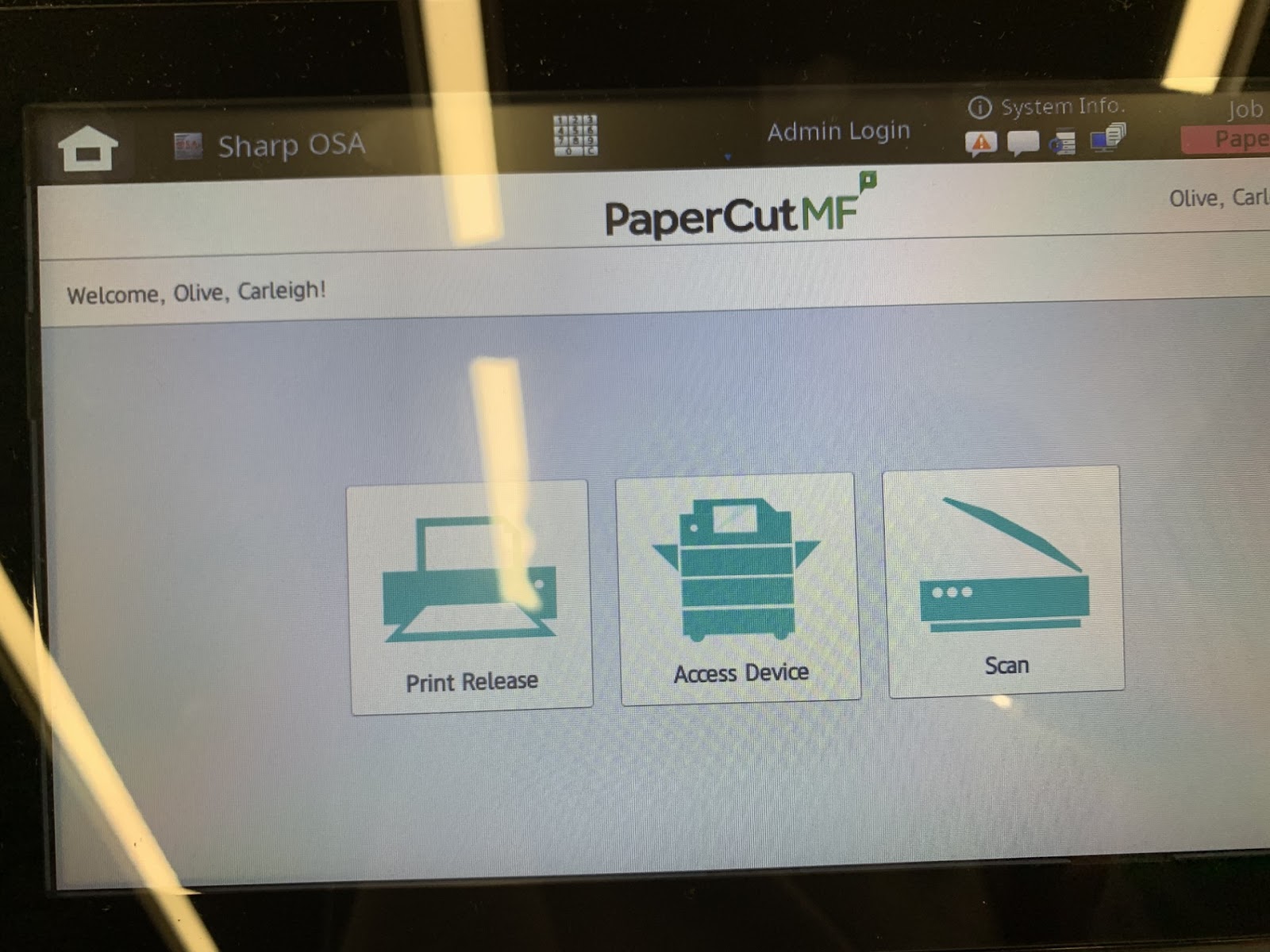 Picture of the screen on the copier that has three icons. The one on the far left with the printer graphic says "Print Release." The one in the middle with a graphic of their copier says "Access Device." The graphic of a scanner on the far right says "Scan."