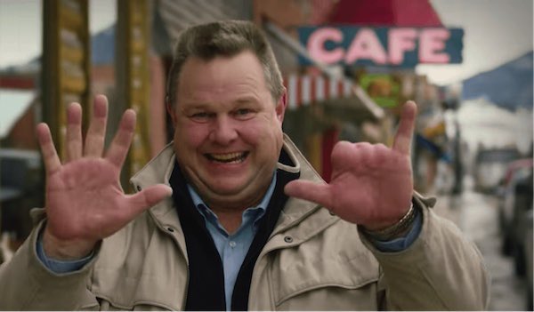 Jon Tester holding up his 7 fingers and smiling.