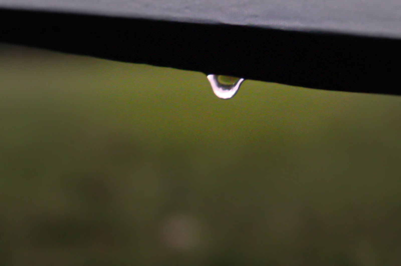 a drop of water collects on the edge of a tent. 