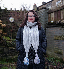 woman wearing a cable knit scarf with tassels