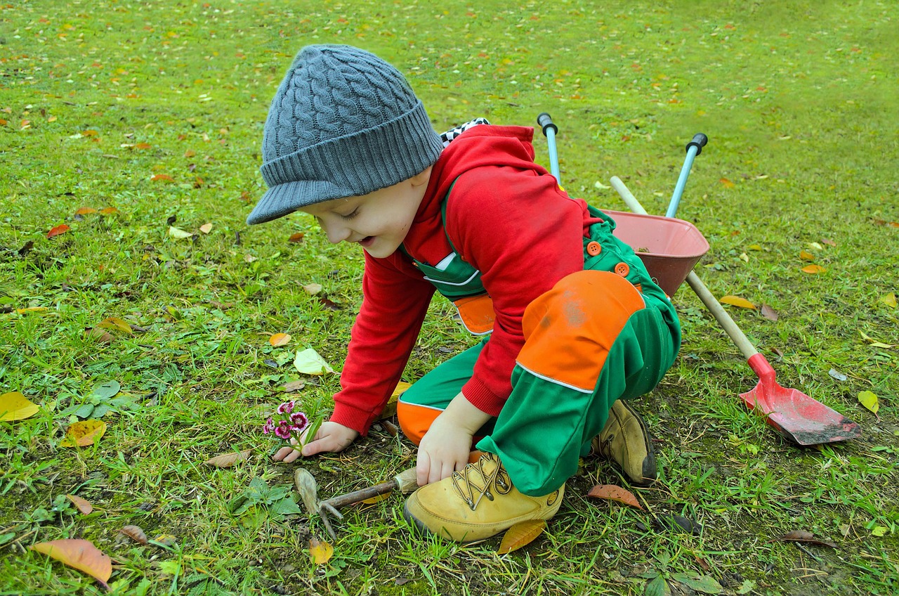 Kid with gardening tools outside