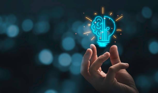 Hand holding drawing virtual lightbulb with brain on bokeh background for creative and smart thinking idea concep stock photo