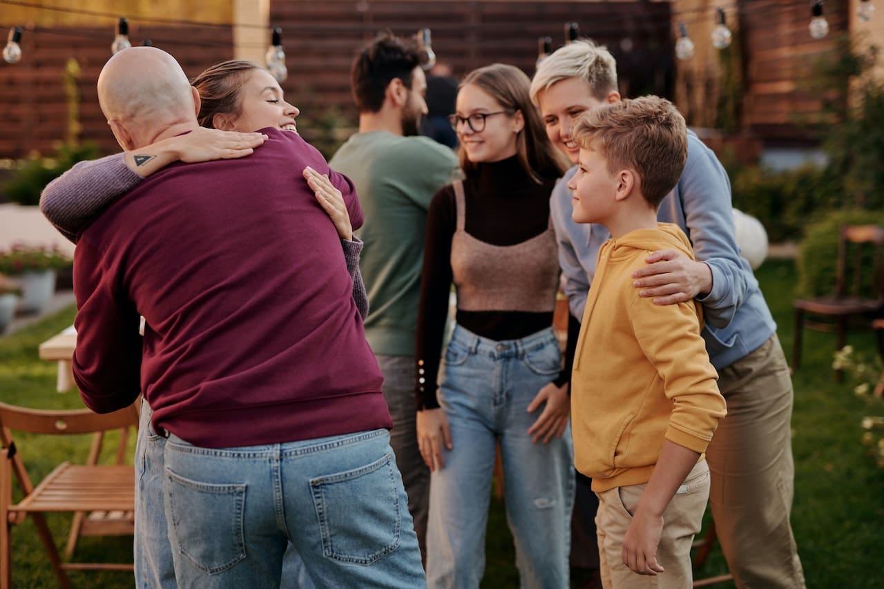 a family with teenage children embrace