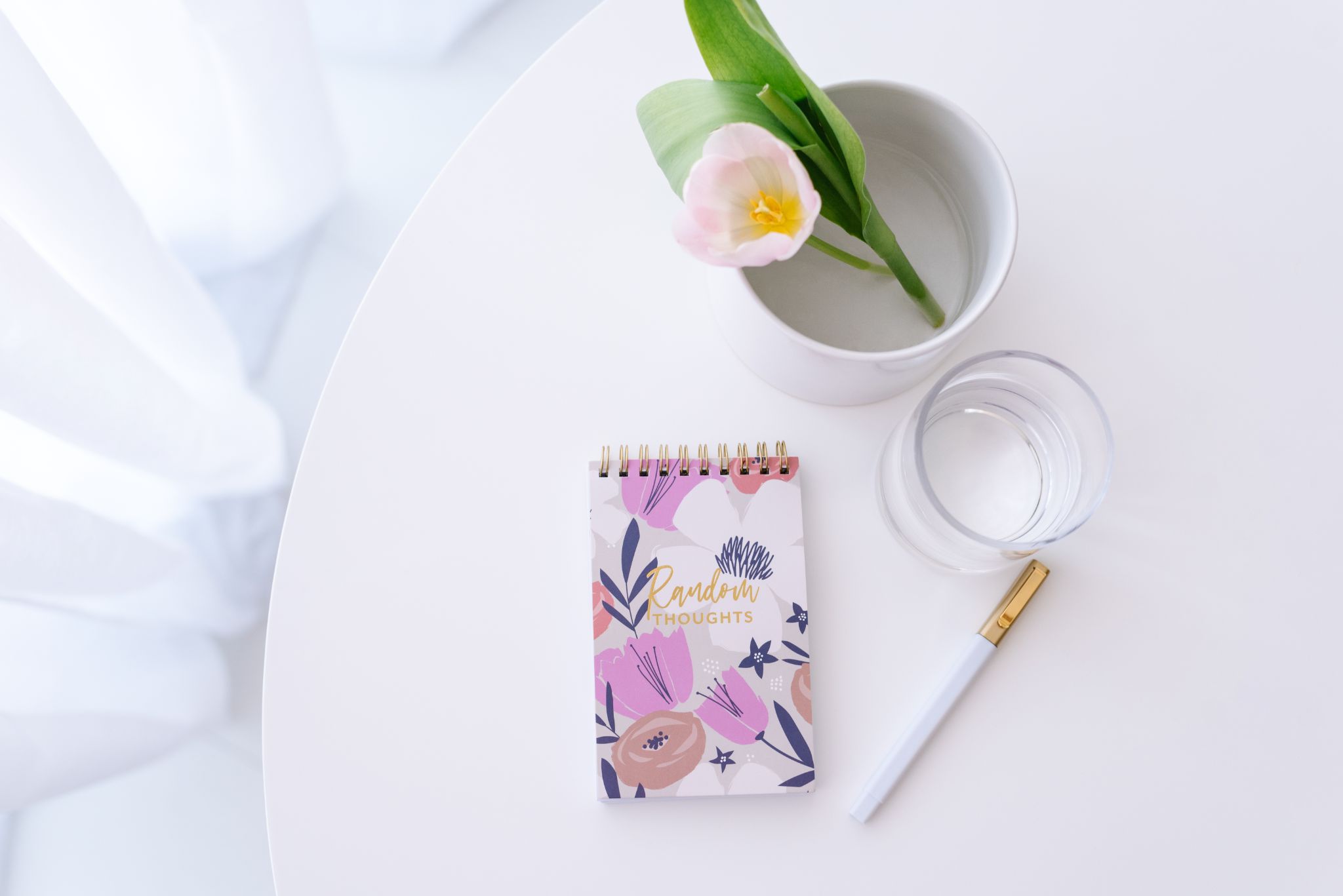 floral notebook beside water and plant