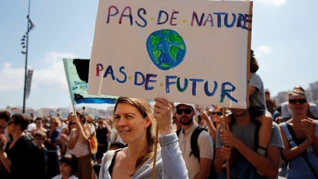 Une femme tient une pancarte sur laquelle on peut lire « Pas de nature, pas de futur ».