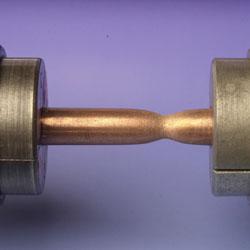 Photograph of a copper specimen undergoing tensile testing