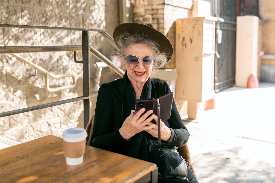 Free Elderly Woman in Black  Holding Black Smartphone Stock Photo