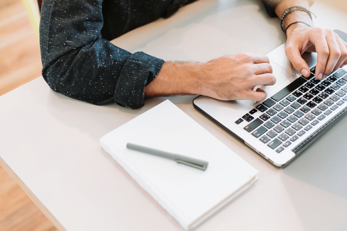 Person Using Laptop on White Surface