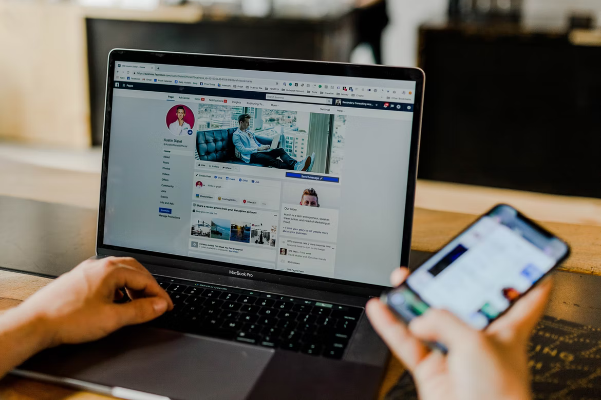 A person managing a Facebook account on a laptop and a smartphone 