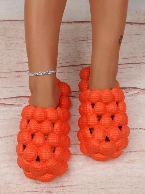 a pair of orange golf ball slippers