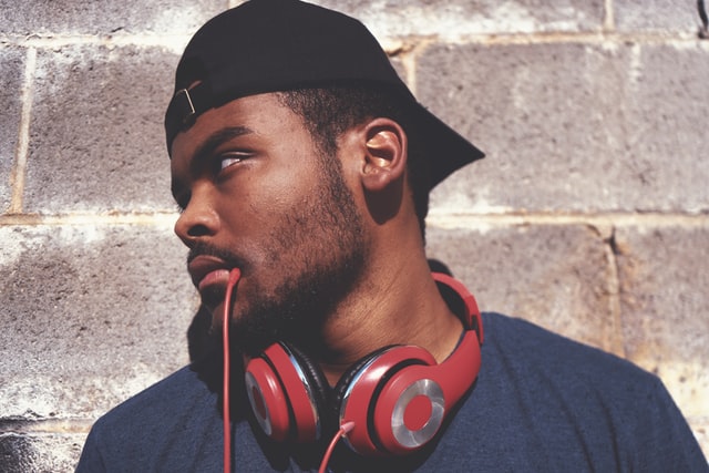 A man wearing headphones with the cable in his mouth