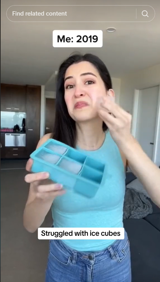 A screenshot of a social media post showing a woman in a blue top rubbing some ice on her face